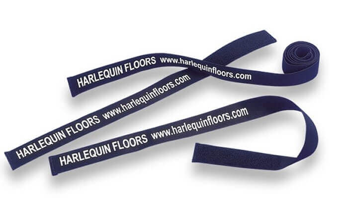 Three unrolled Harlequin roll straps on white background